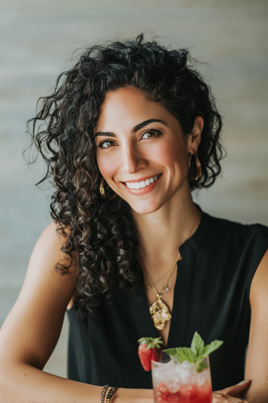 Maraia Tahiri, mocktail expert, smiling with a strawberry mint alcohol-free cocktail