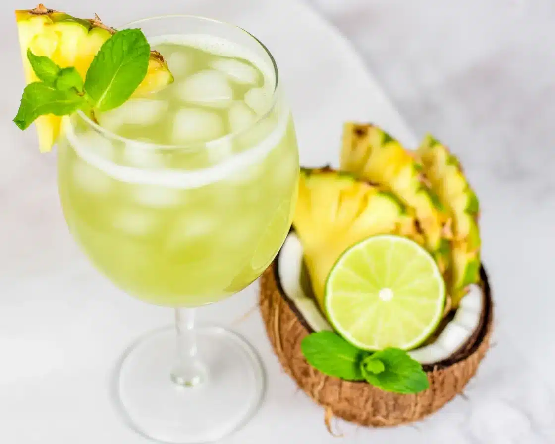 Refreshing Pineapple Crush Mocktail with lime and mint served in a chilled glass.